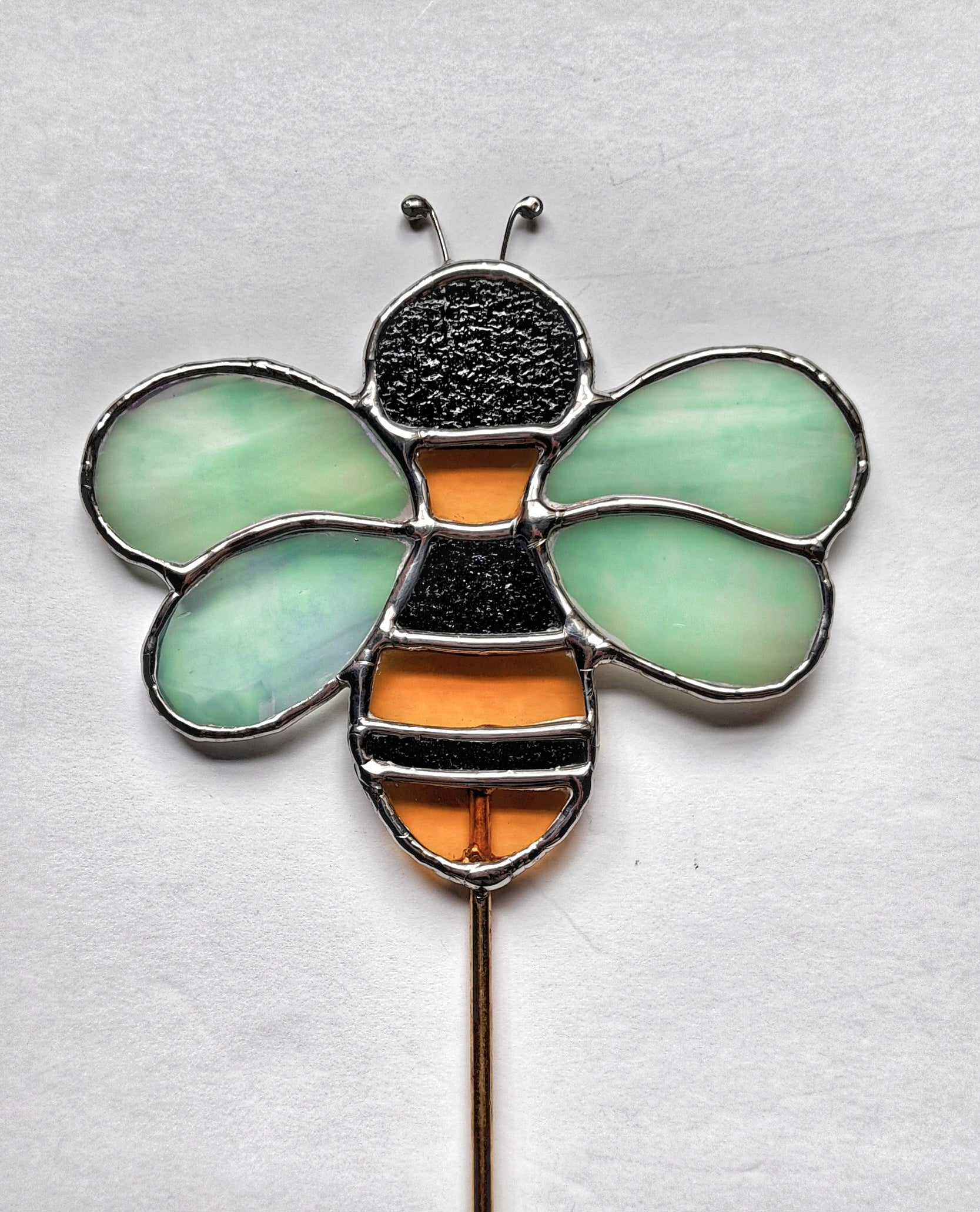 This bee is handcrafted with textured black and yellow glass for the body and iridescent glass for the wings.